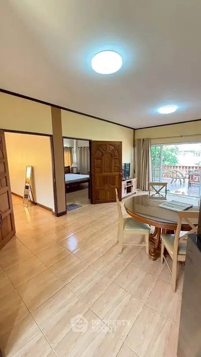 Spacious living room with dining area and balcony access in a modern apartment.