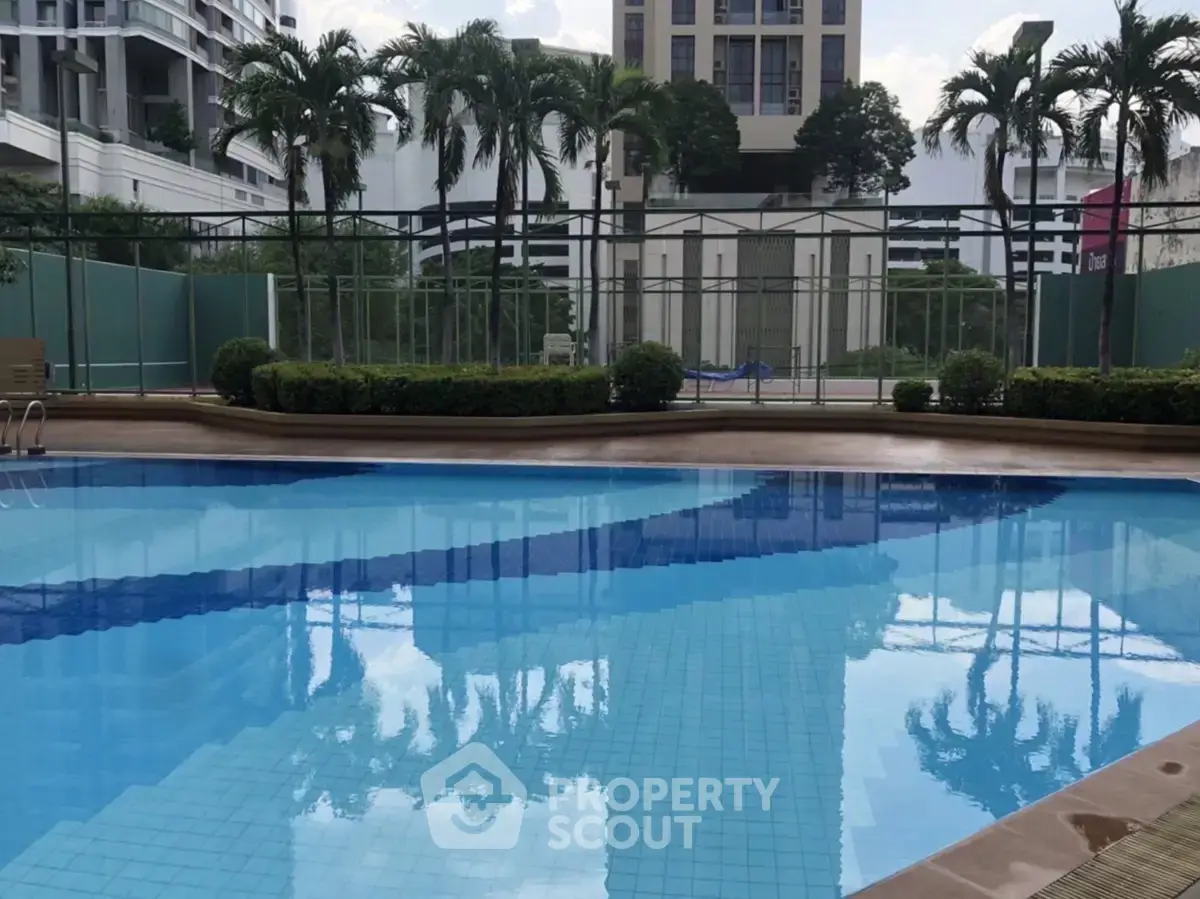 Luxurious residential pool area with palm trees and modern architecture, perfect for relaxation and leisure.