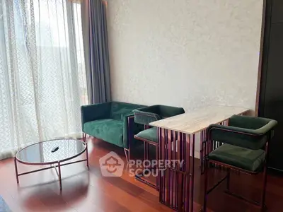 Stylish modern living room with elegant green furniture and sleek wooden flooring.
