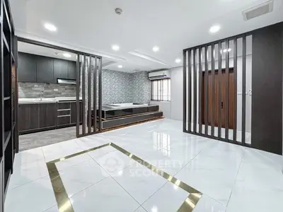 Modern open-plan living area with sleek kitchen and stylish partition design.