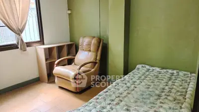 Cozy bedroom with recliner and natural light, perfect for relaxation.