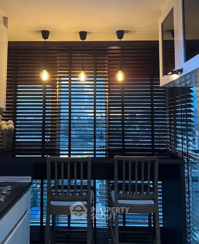 Chic modern kitchen with stylish lighting and city view, perfect for urban living.