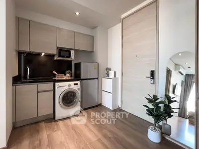 Modern compact kitchen with washing machine and fridge in stylish apartment