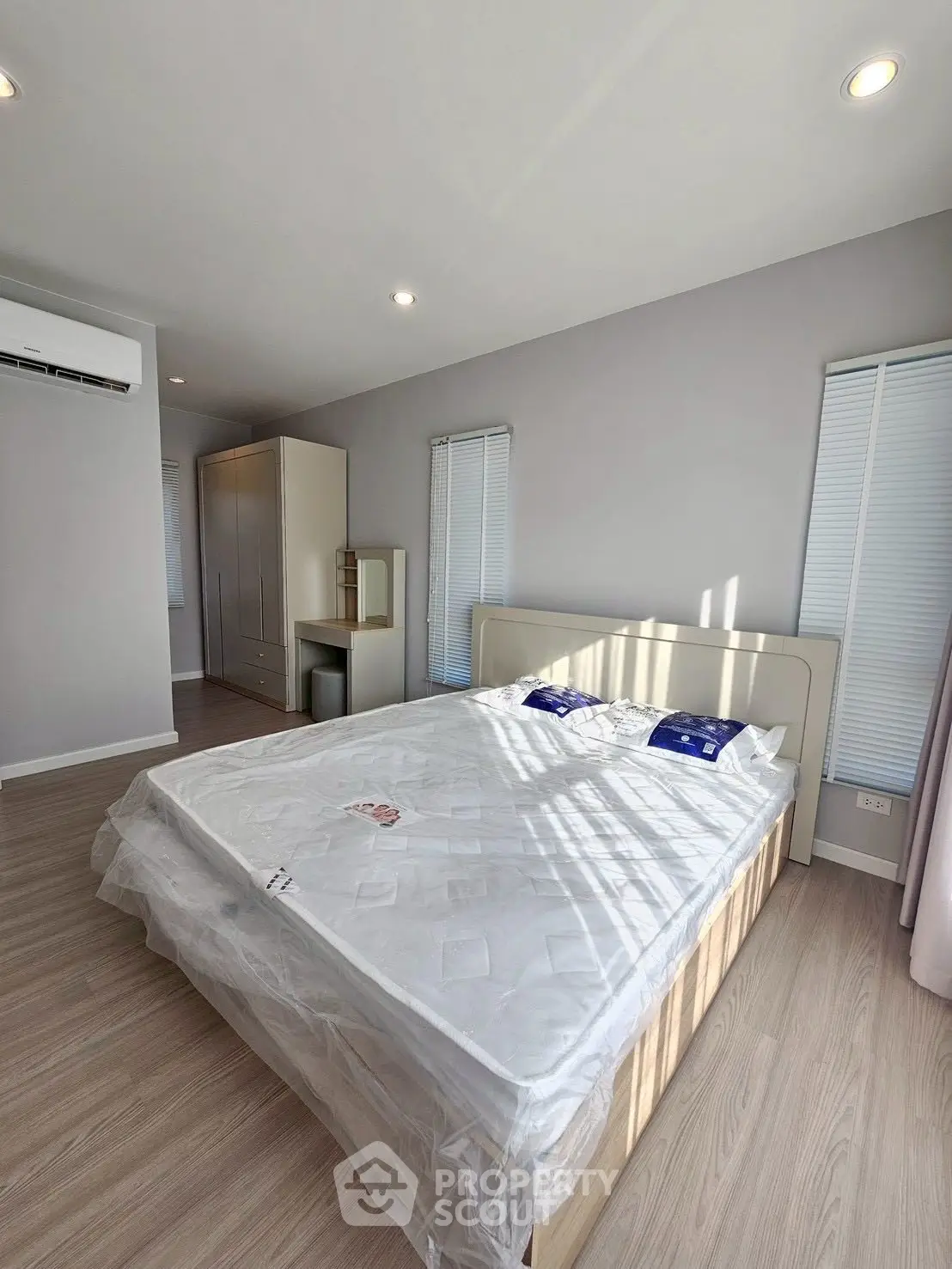 Spacious bedroom with modern design and natural light, featuring a comfortable bed and sleek wardrobe.