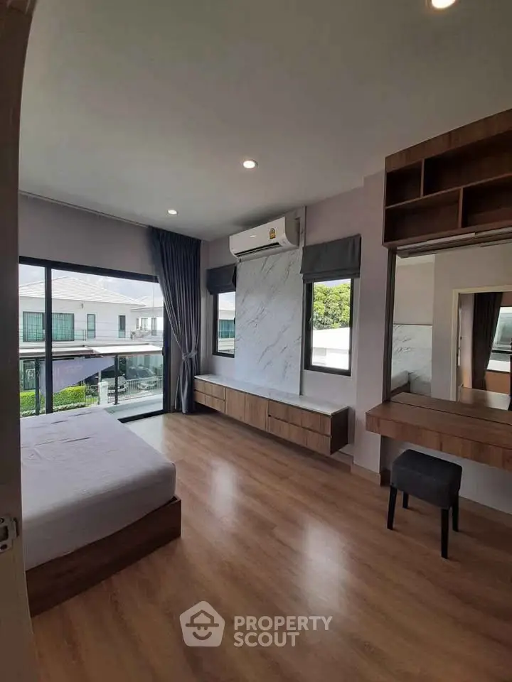 Spacious modern bedroom with large windows and elegant wooden flooring