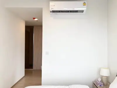 Minimalist bedroom with air conditioning and soft lighting, perfect for relaxation.