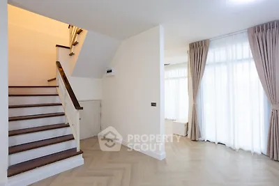 Spacious modern living area with elegant staircase and large windows