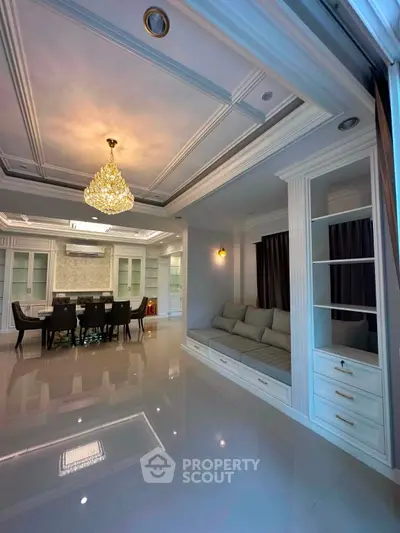 Luxurious living room with elegant chandelier and spacious dining area, perfect for entertaining guests.