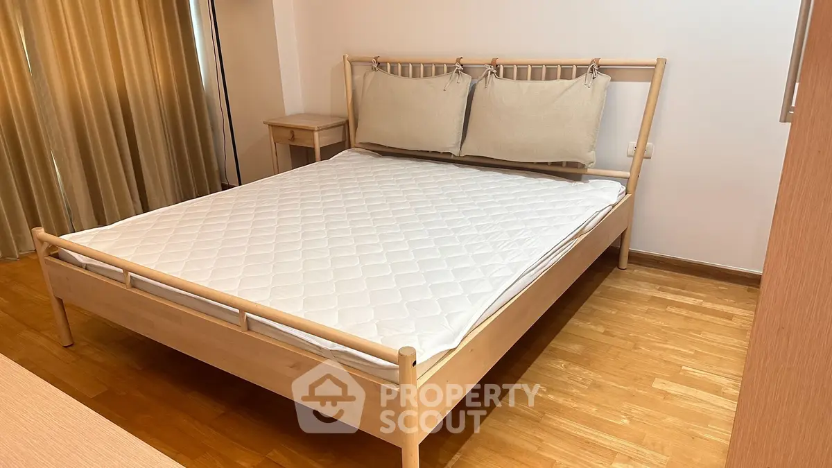 Spacious bedroom with wooden bed frame and cozy decor