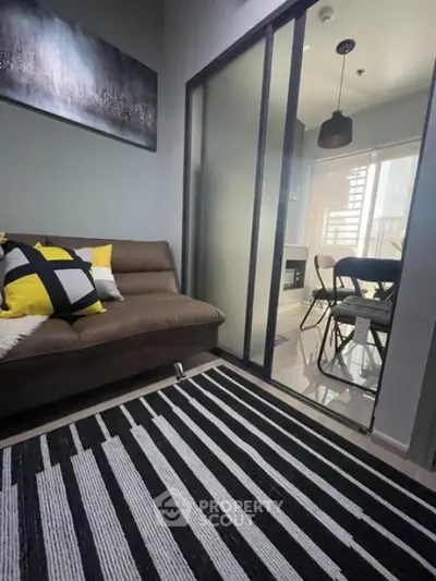 Modern living room with stylish decor and glass sliding doors leading to dining area