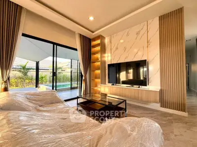 Luxurious living room with modern decor and pool view, featuring elegant marble accents and large sliding doors.