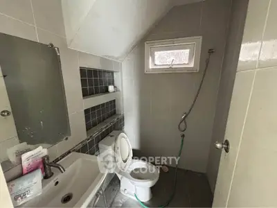 Compact bathroom with modern fixtures and gray tile design