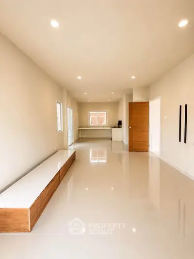 Spacious modern living room with sleek flooring and ample natural light, perfect for contemporary living.