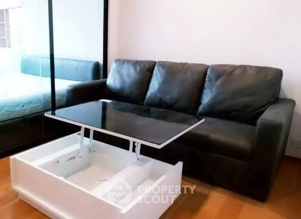 Modern living room with sleek black sofa and innovative lift-top coffee table.