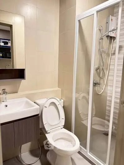 Modern bathroom with shower enclosure and sleek vanity in a contemporary apartment.