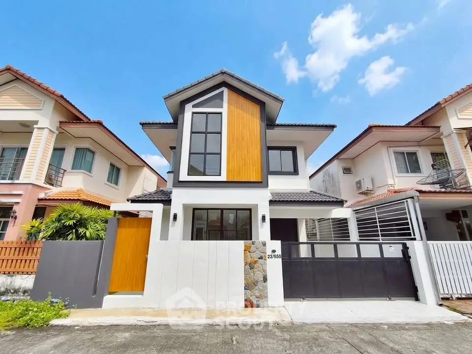 Modern two-story house with unique facade and spacious driveway in a suburban neighborhood.