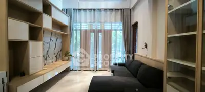 Spacious modern living room with large windows and elegant shelving.