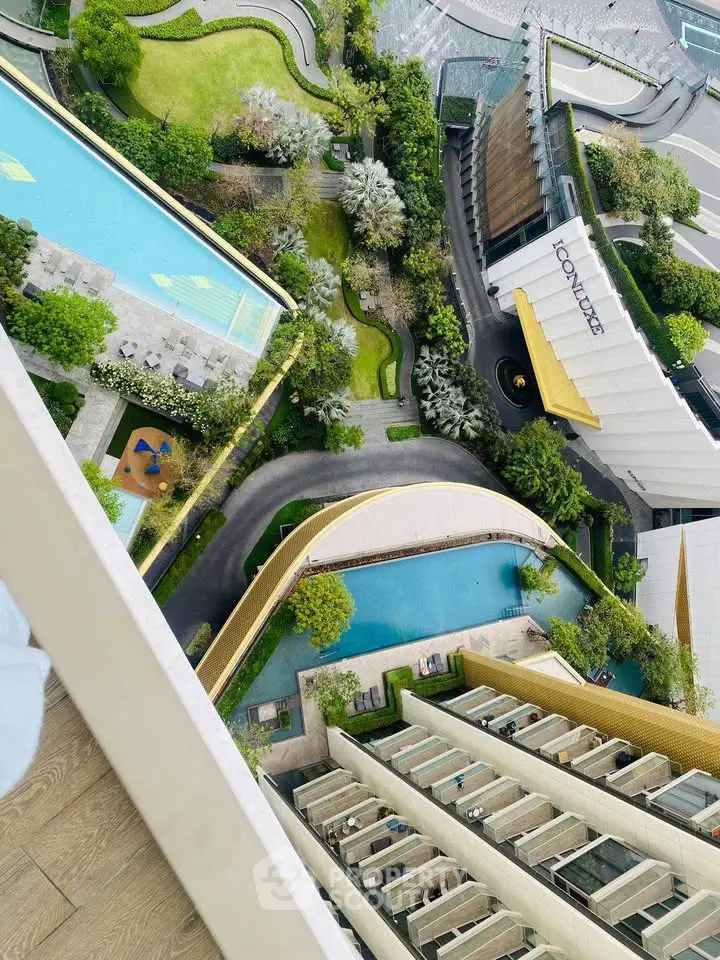 Stunning aerial view of luxury residential complex with lush gardens and inviting swimming pools.