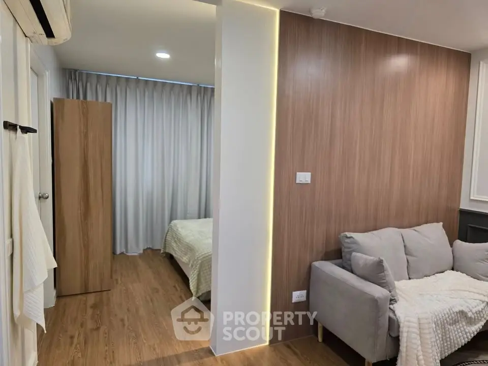 Modern apartment interior with cozy living room and bedroom, featuring wood paneling and soft lighting.
