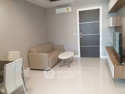 Modern living room with sleek furniture and wall-mounted TV in a stylish apartment.