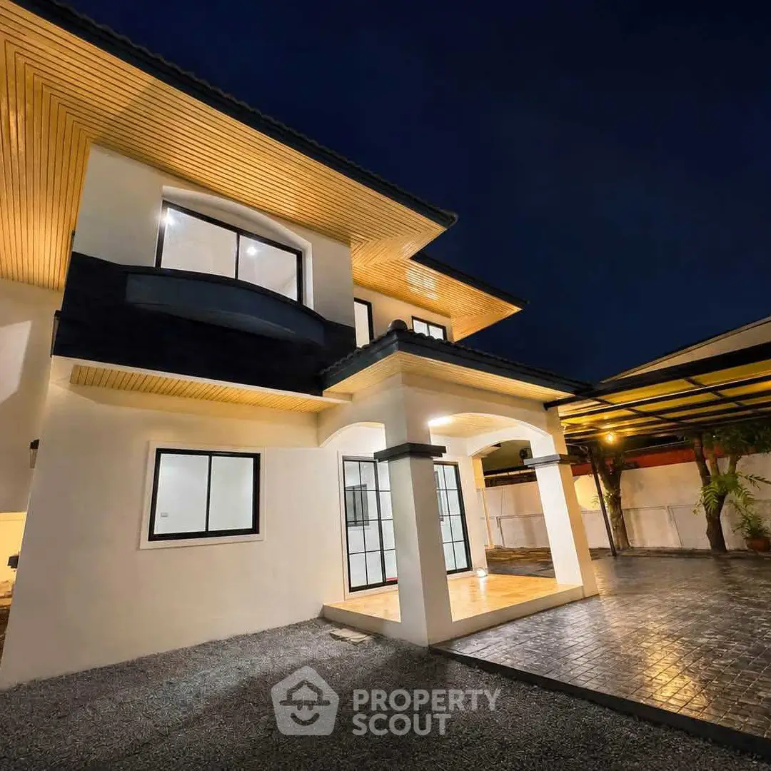 Stunning modern two-story house with elegant exterior lighting and spacious driveway at night.