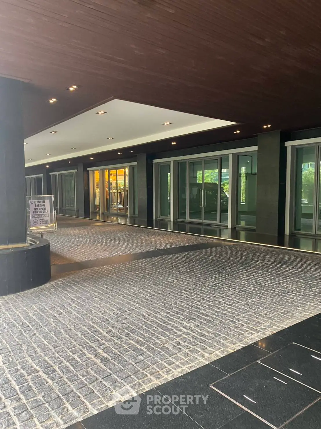 Elegant building entrance with modern design and cobblestone driveway