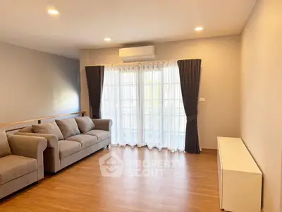 Spacious living room with elegant sofa and large window for natural light