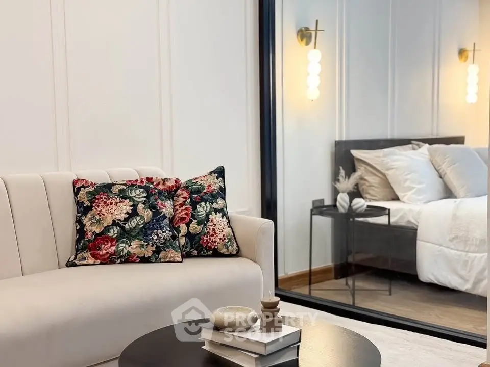 Elegant living room with floral cushions and view into cozy bedroom