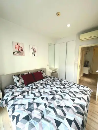 Modern bedroom with geometric bedding and stylish decor in a bright apartment.