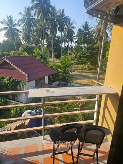 Charming balcony with lush tropical view, perfect for relaxation and enjoying nature's beauty.