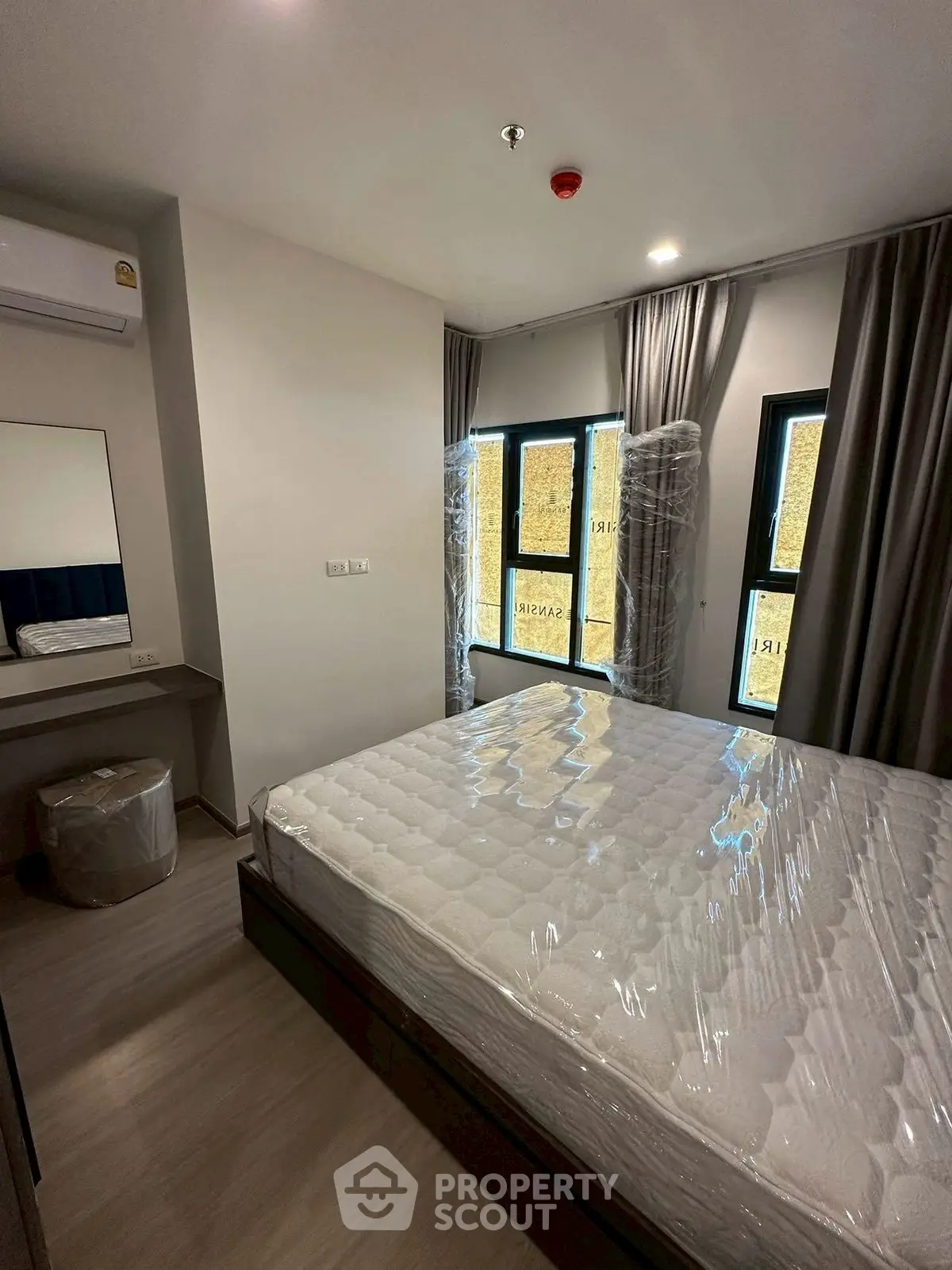 Modern bedroom with large windows and stylish decor in a contemporary apartment.