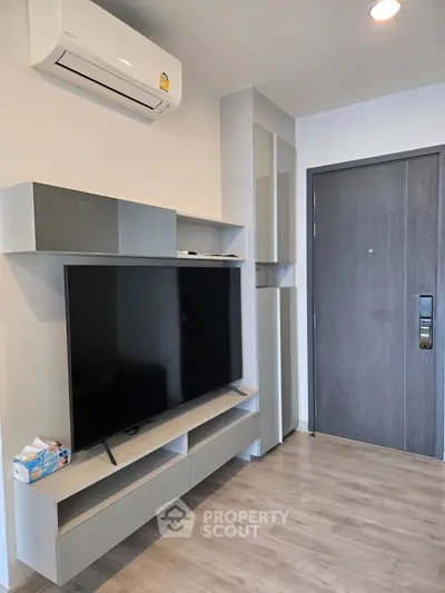 Modern living room with sleek TV setup and air conditioning unit