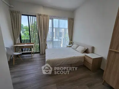 Spacious bedroom with modern decor and large windows for natural light.