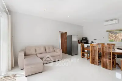 Spacious living room with modern furniture and dining area, featuring a sleek kitchen setup.
