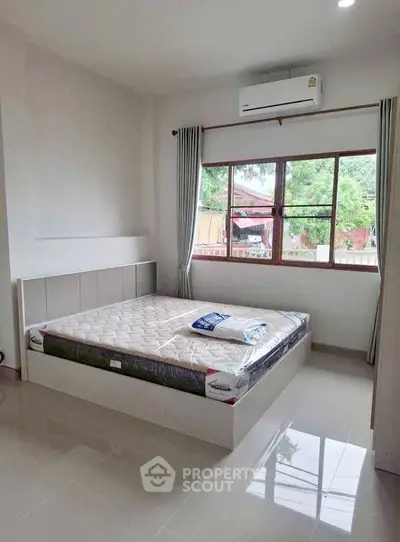 Spacious bedroom with large window and air conditioning, perfect for comfort and relaxation.