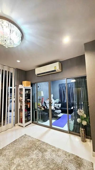 Modern living room with air conditioning and glass doors leading to cozy interior.