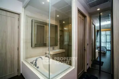 Modern bathroom with glass-enclosed bathtub and sleek fixtures