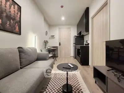 Modern living room with sleek kitchen, cozy sofa, and stylish decor in a compact apartment.