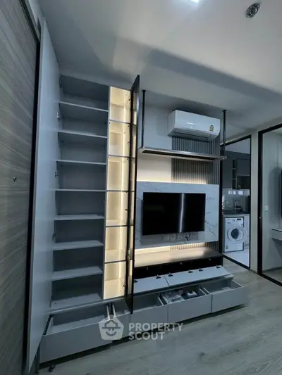 Modern living room with sleek storage, TV unit, and built-in air conditioning.