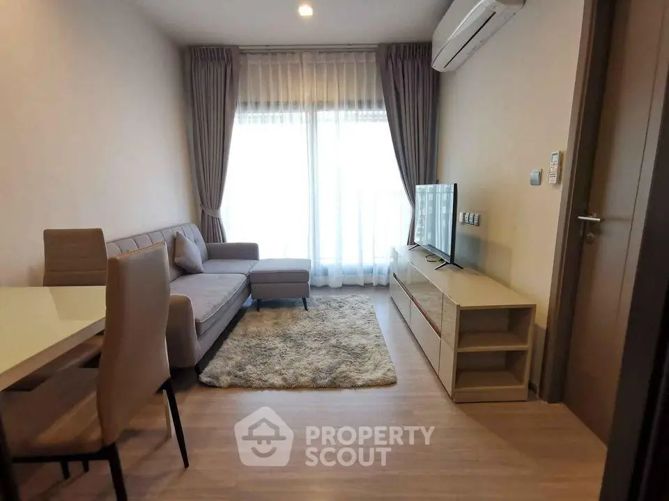 Modern living room with cozy sofa, TV, and dining area in a stylish apartment.