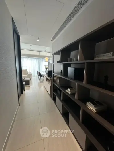 Modern apartment hallway leading to a bright living room with stylish shelving and contemporary decor.