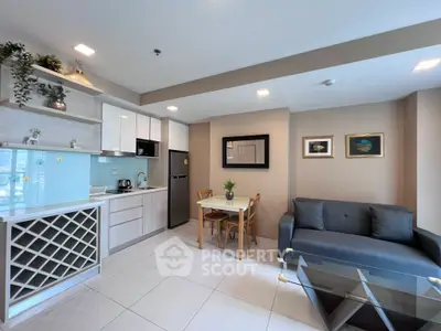 Modern open-layout kitchen and living room with stylish decor and ample natural light.