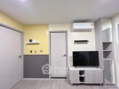 Modern living room with sleek TV unit and air conditioning, featuring minimalist decor and neutral tones.