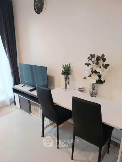 Modern living room with sleek furniture and stylish decor, featuring a TV and elegant dining setup.