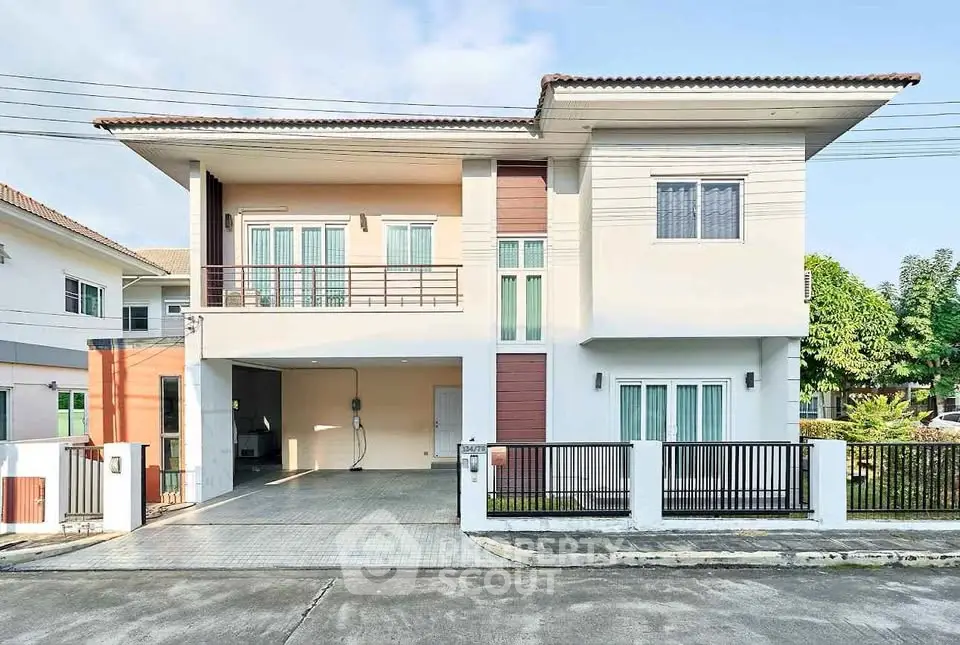 Modern two-story house with spacious driveway and balcony in suburban neighborhood.