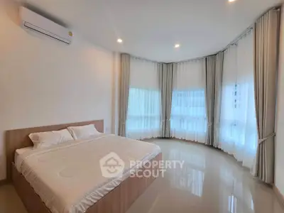 Spacious bedroom with large windows and modern decor, perfect for natural light lovers.
