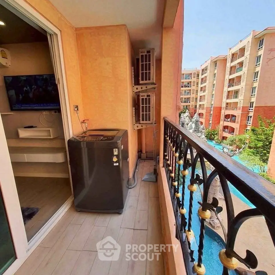 Charming balcony view with pool and modern appliances in vibrant residential complex.