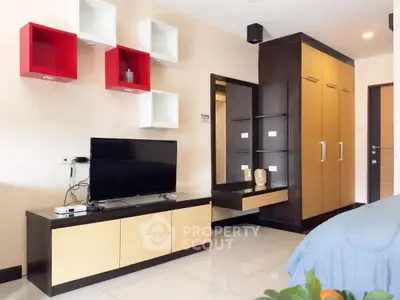 Modern bedroom with stylish TV unit and wardrobe, featuring sleek design and vibrant wall accents.