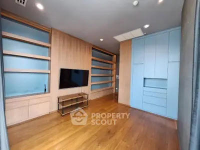 Spacious modern living room with built-in shelves and wooden flooring