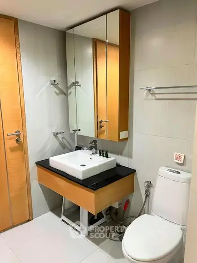 Modern bathroom with sleek design featuring a stylish sink and toilet in a contemporary setting.